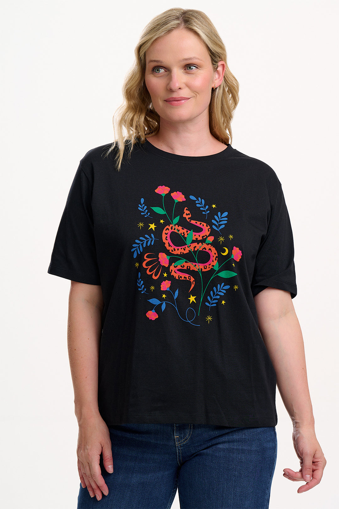 Woman wearing a black t-shirt with colorful snake and floral design on a white background
