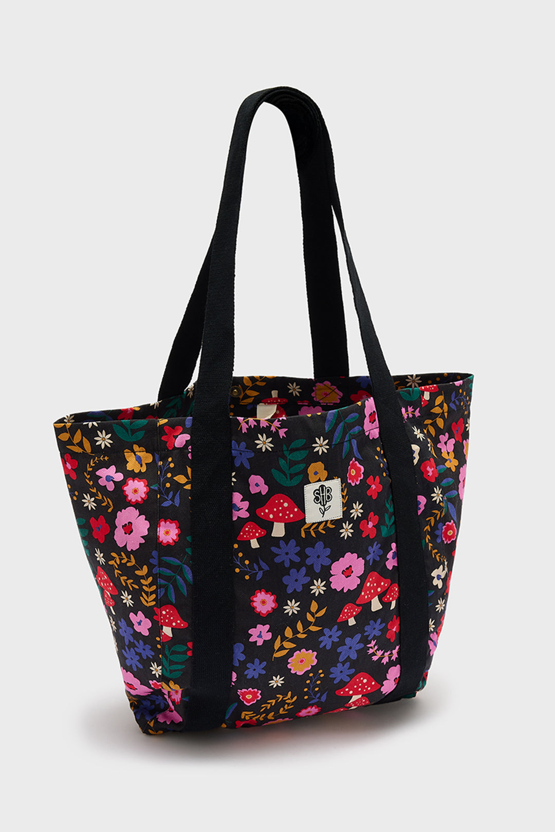 Floral patterned tote bag with black handles on a white background