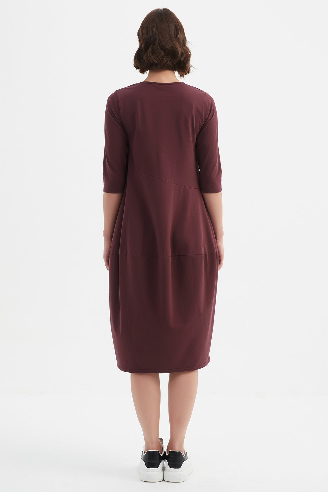 Person wearing a burgundy dress on a white background