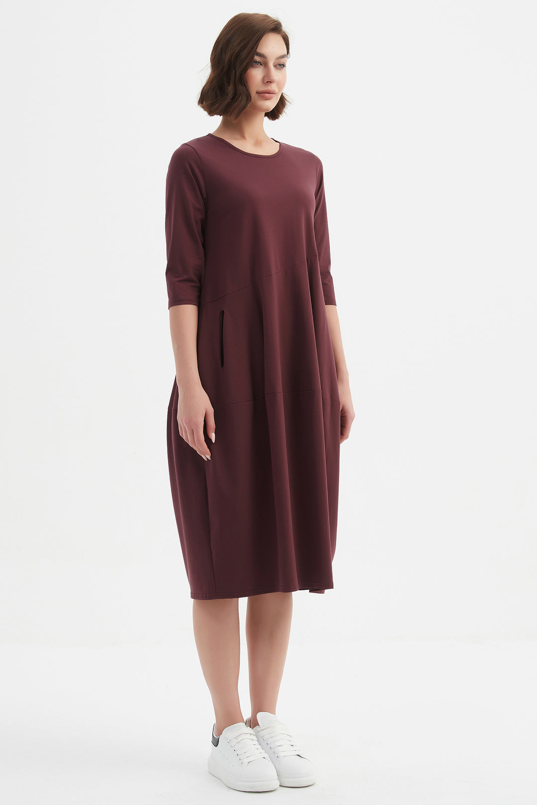 Woman wearing a burgundy dress on a white background