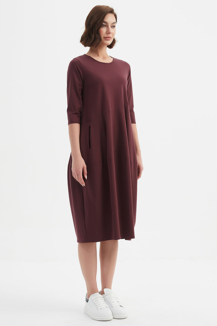 Woman wearing a burgundy dress on a white background