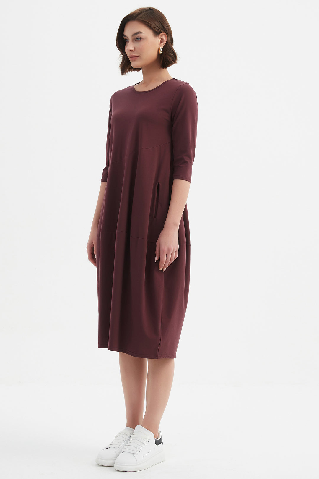 Woman wearing a maroon dress on a white background