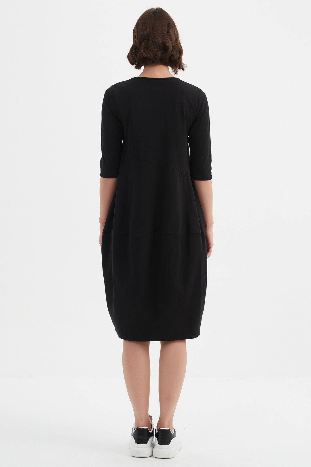 Person wearing a black dress on a white background