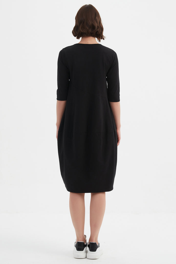 Person wearing a black dress on a white background