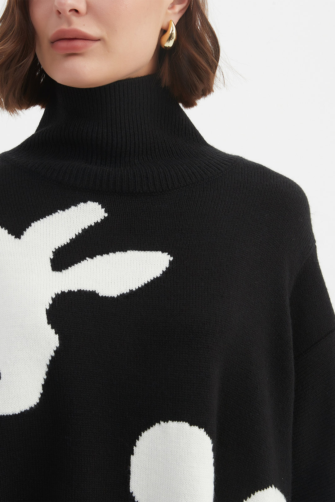 Black turtleneck sweater with white bunny design worn by a person.