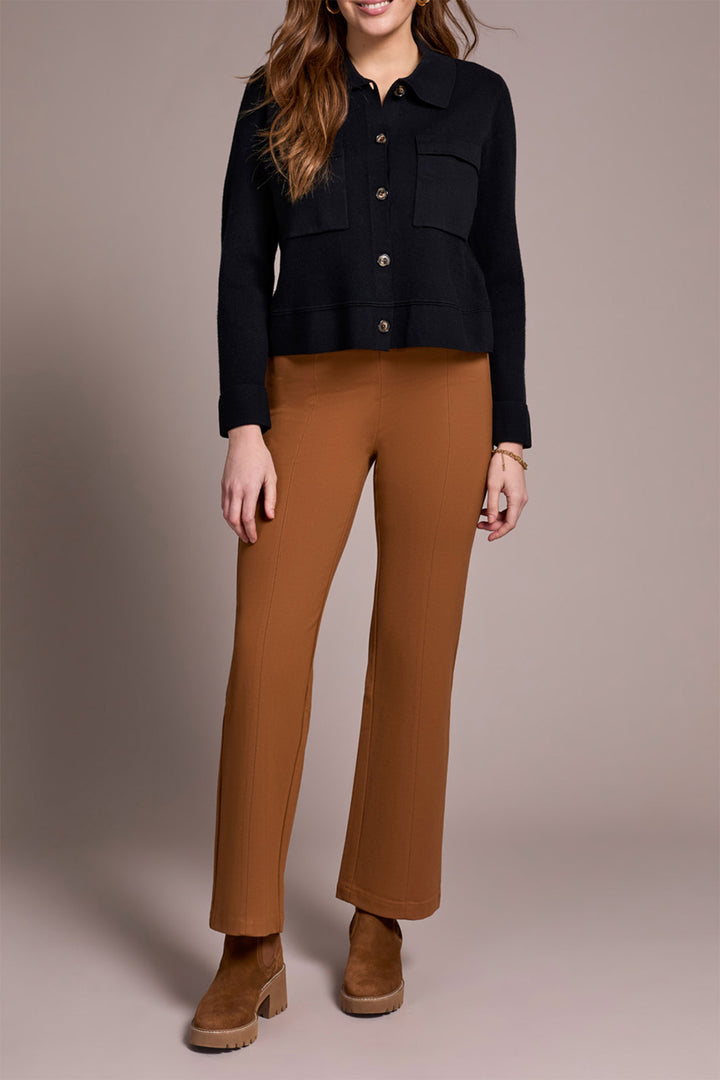 Person wearing a black jacket and brown pants on a plain background
