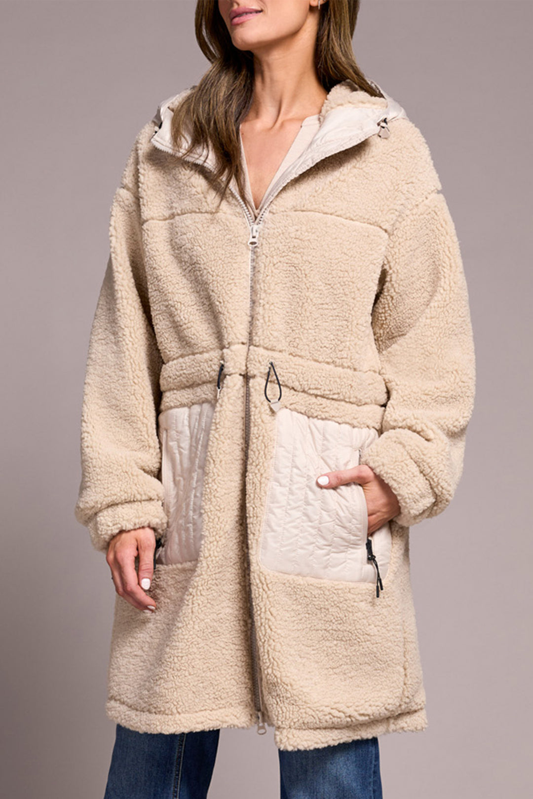 Beige fleece coat worn by a person on a plain background