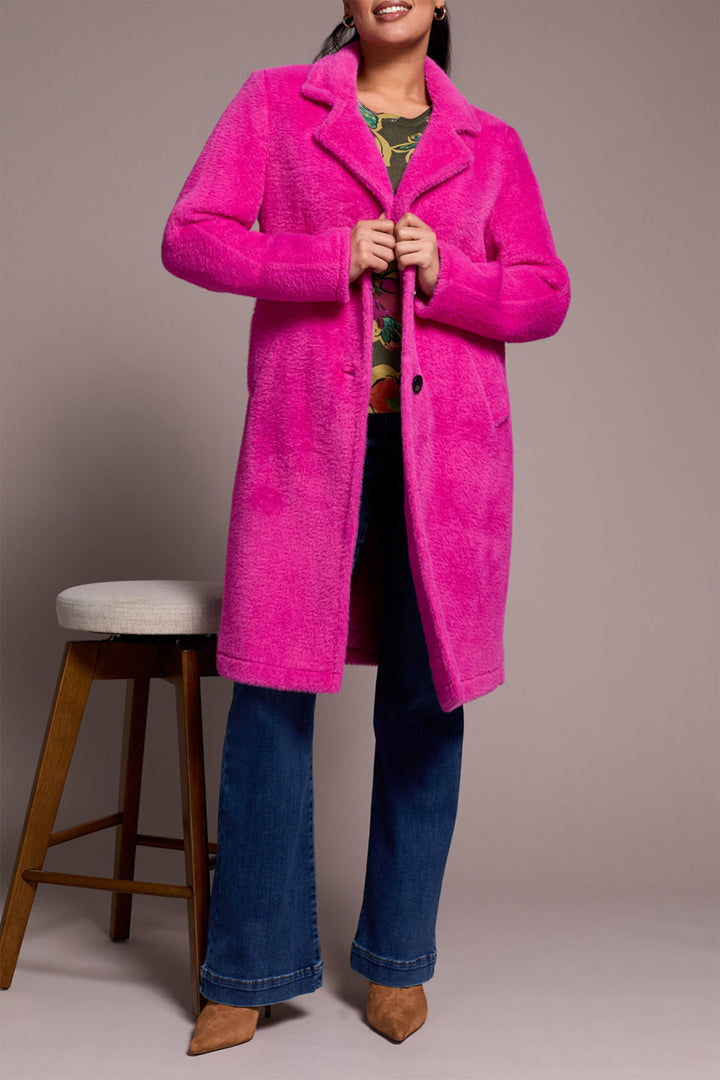 Person wearing a bright pink coat with a plain background