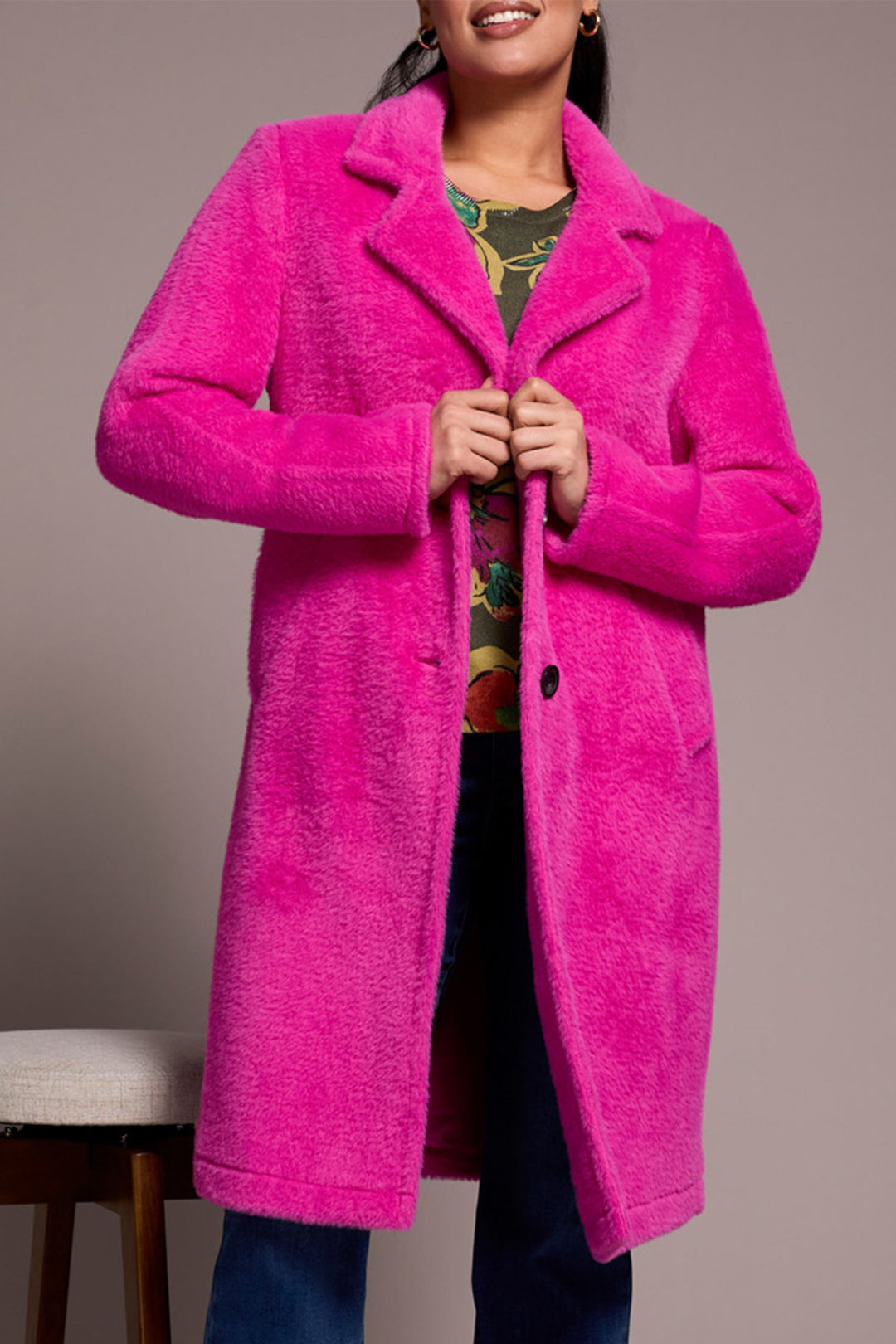 Person wearing a bright pink coat against a neutral background