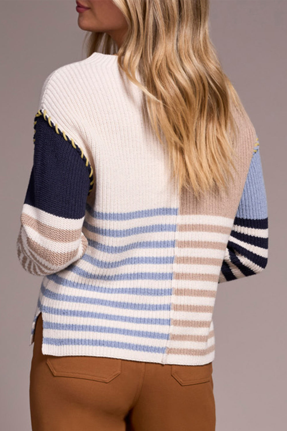 Person wearing a striped sweater with a neutral background