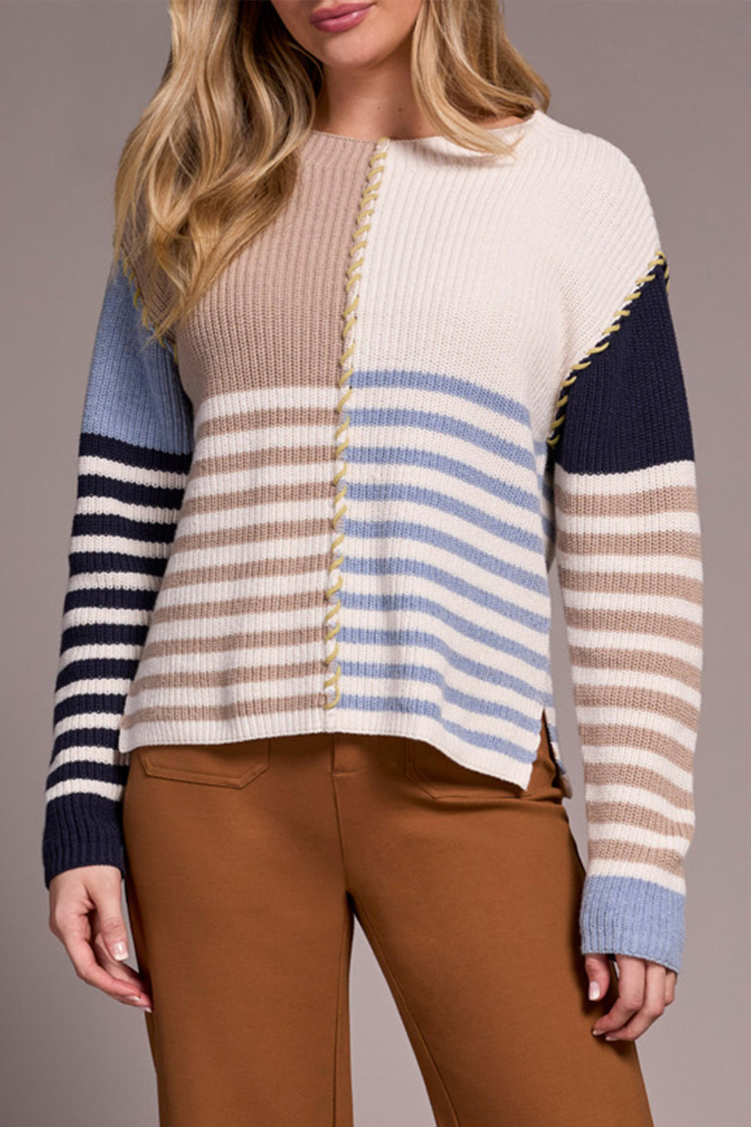 Woman wearing a striped sweater with a neutral background