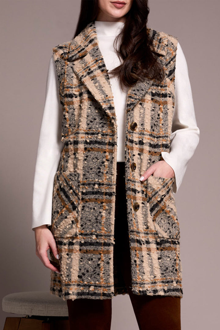 Woman wearing a patterned vest over a white shirt on a plain background