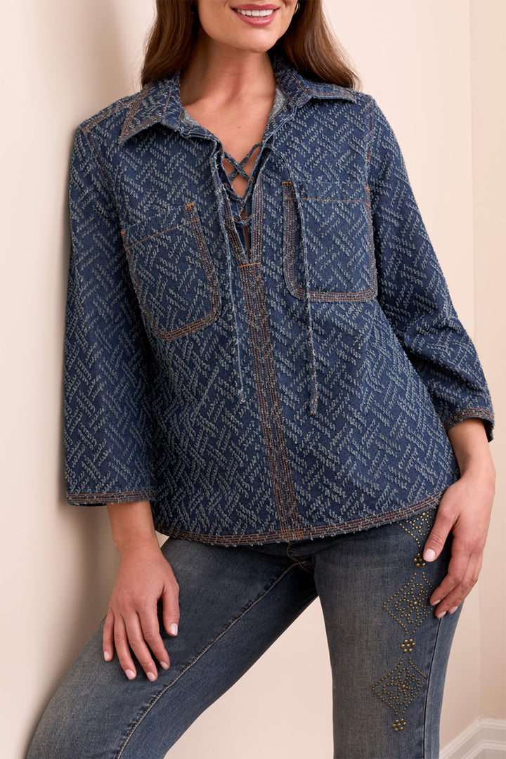 Woman wearing a blue patterned jacket and jeans against a beige background