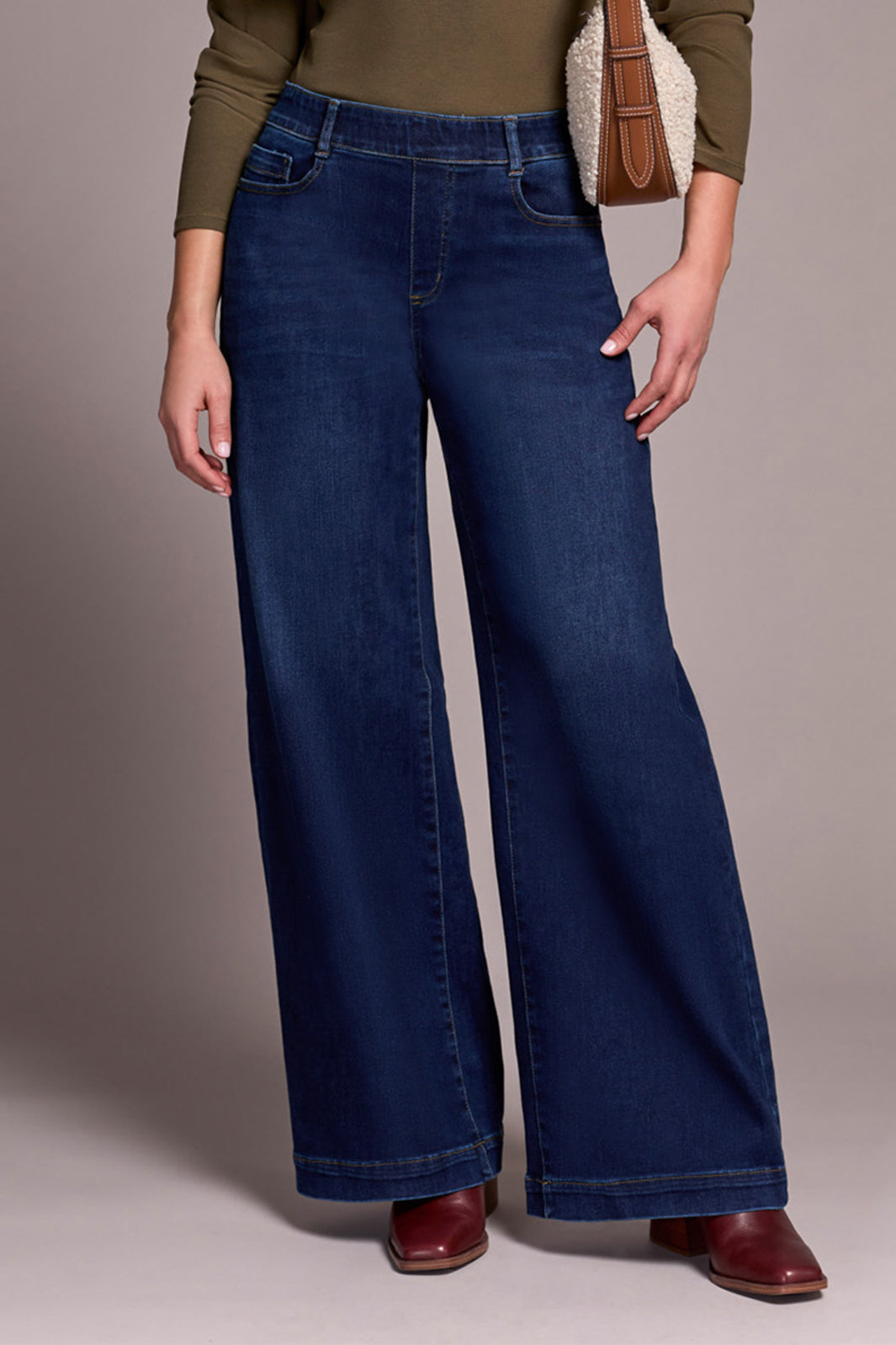 Person wearing wide-leg jeans with a plain background