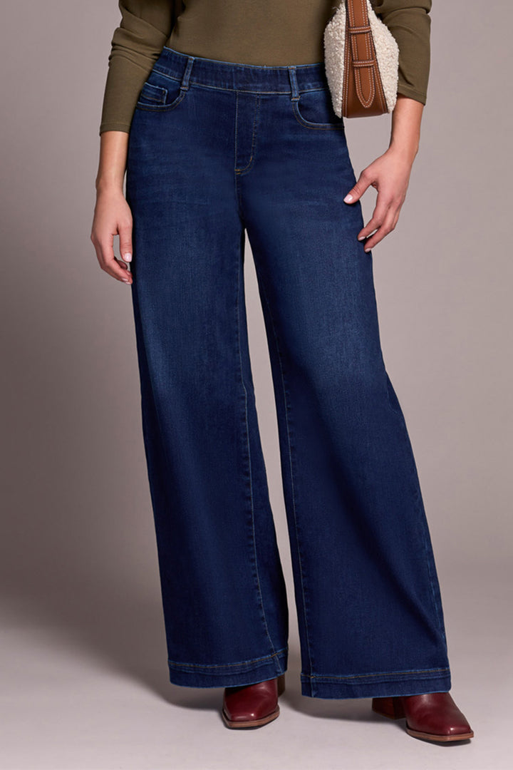 Person wearing wide-leg jeans with a plain background