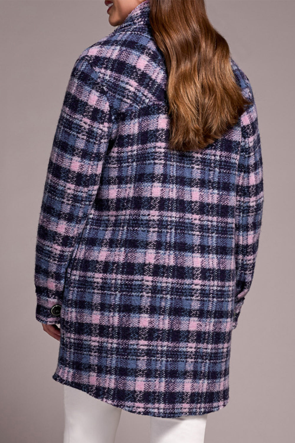 Plaid coat worn by a person on a plain background