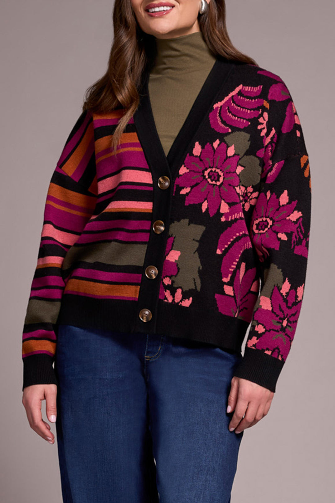 Woman wearing a colorful floral cardigan with a striped pattern on a plain background