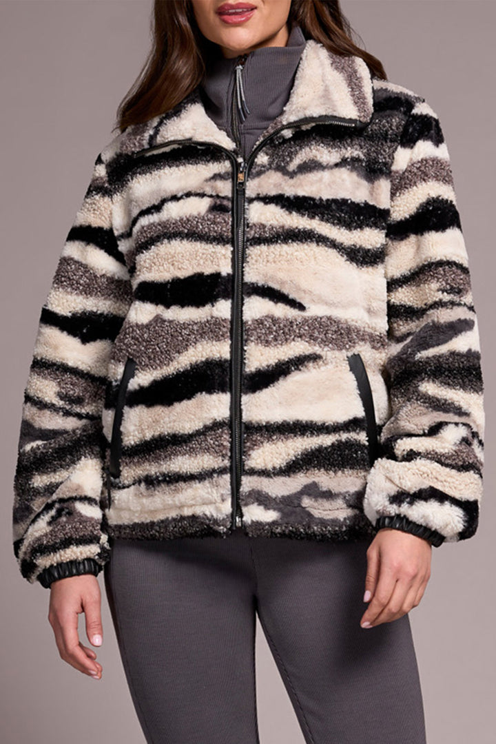 Zebra-striped jacket worn by a person on a neutral background