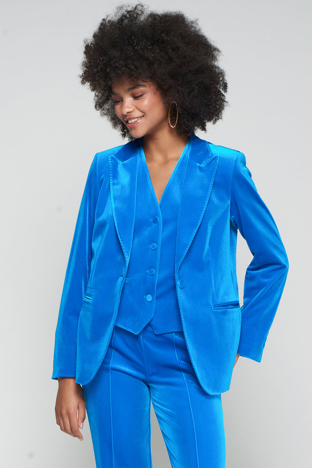 Woman wearing a bright blue suit against a plain background