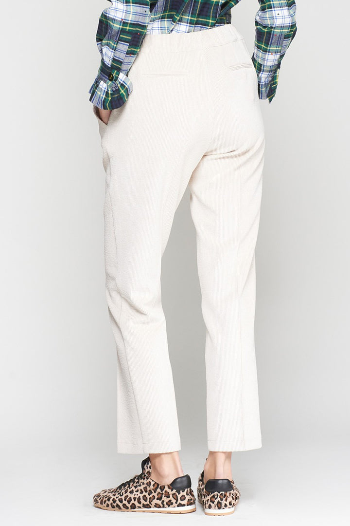 Person wearing white pants and a plaid shirt with leopard print shoes on a white background